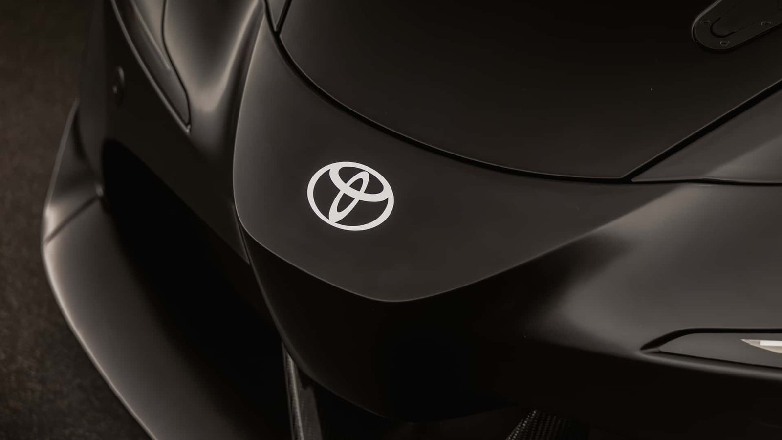 A sleek electric vehicle driving down a futuristic city street.