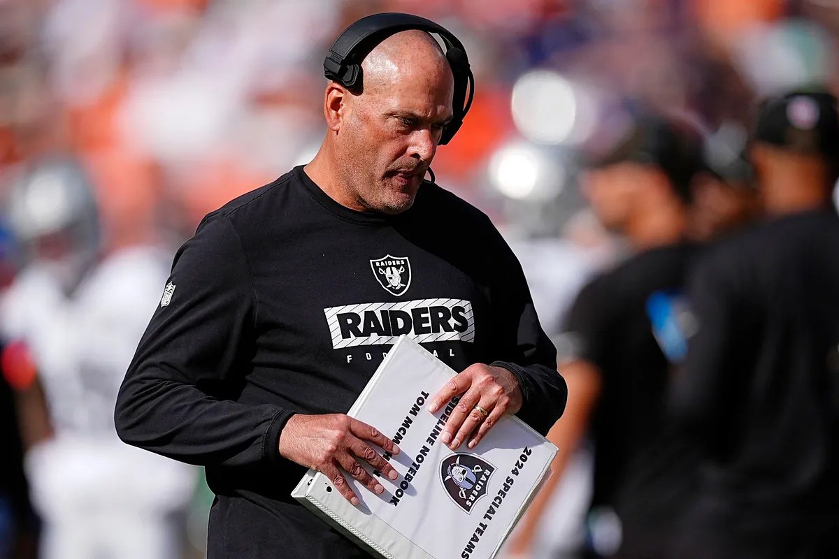 The Las Vegas Raiders coaching staff looking dejected on the sidelines after a particularly poor play during a recent game.