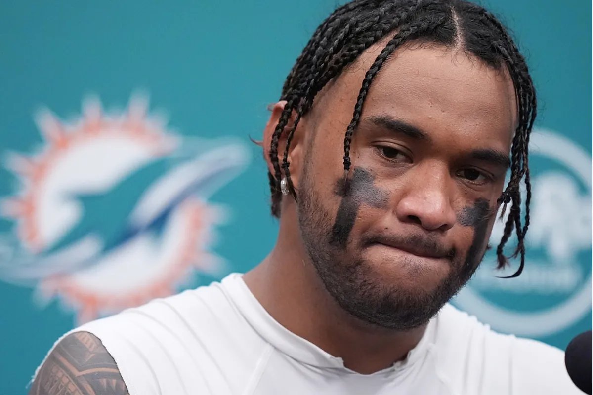 Tua Tagovailoa looking dejected on the field after a tough loss, reflecting on the Dolphins' season struggles and the need for accountability.