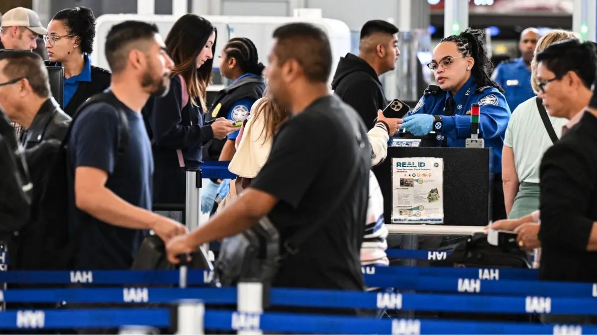 A confused traveler searching through their bag at a TSA checkpoint.