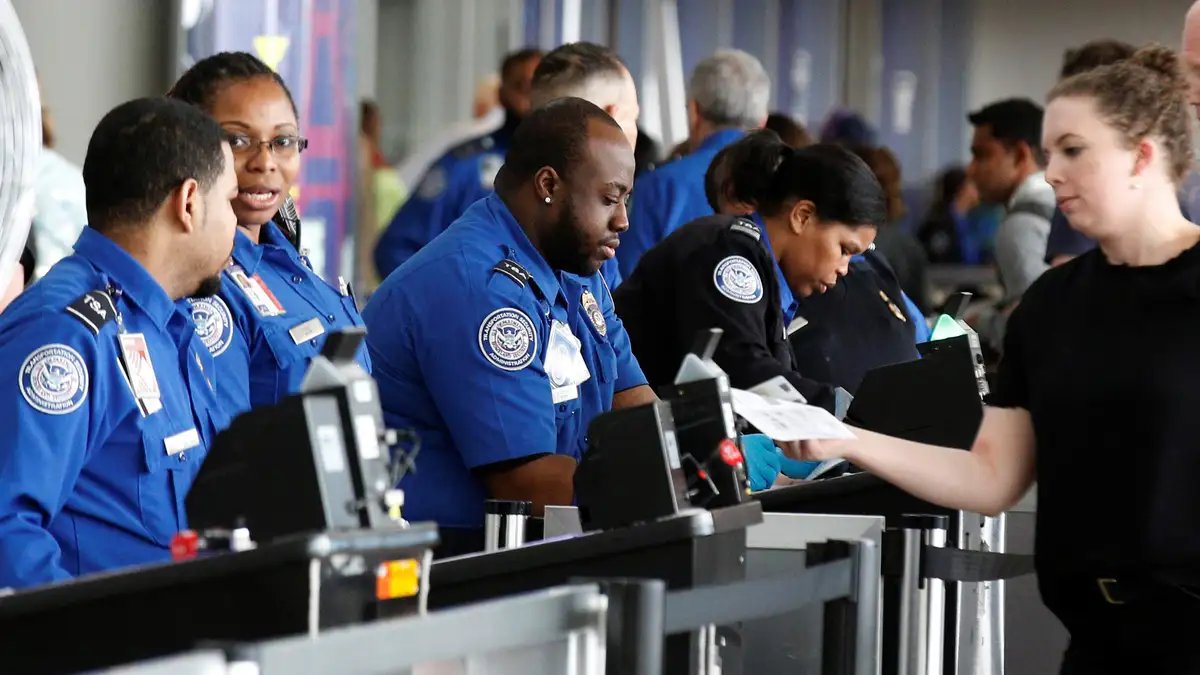 A TSA checkpoint line with frustrated travelers waiting to be screened.