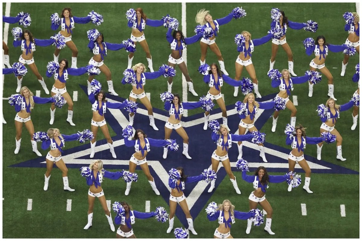 Dallas Cowboys Cheerleaders in festive pajamas interacting with children at their Christmas pajama party, surrounded by holiday decorations.