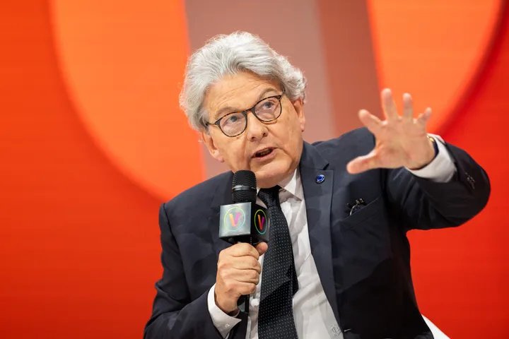 A person typing on a laptop with a backdrop of global network connections, symbolizing the interconnectedness and complexities of online content.