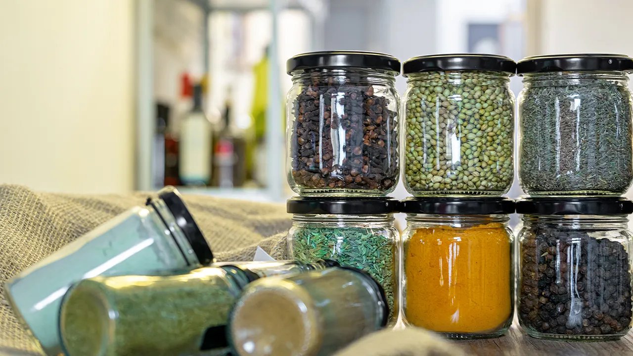 A vibrant display of various common kitchen spices and herbs, including turmeric, cinnamon sticks, ginger, and garlic bulbs, highlighting their natural beauty and health potential.