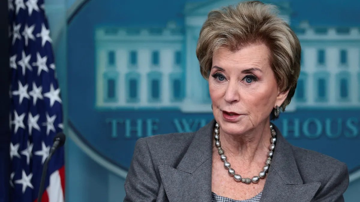 Former education staff members gather outside the department building, discussing the unexpected call to return.