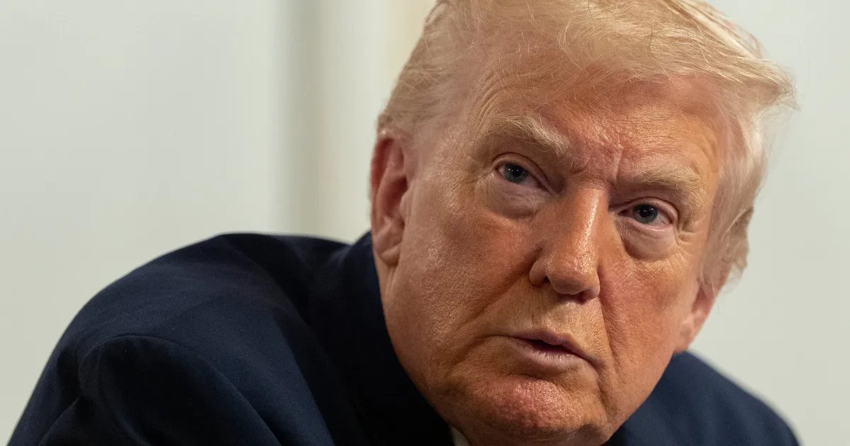 Donald Trump arriving at court amidst a crowd of reporters and photographers.