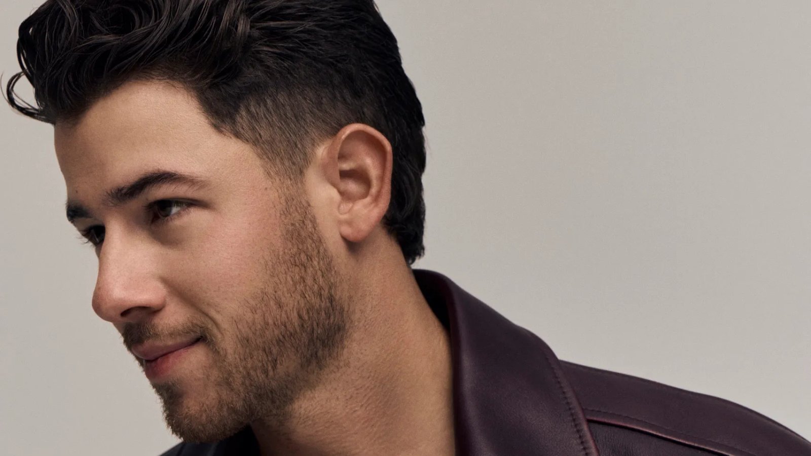 Close-up of Nick Jonas singing into a microphone, focused expression.