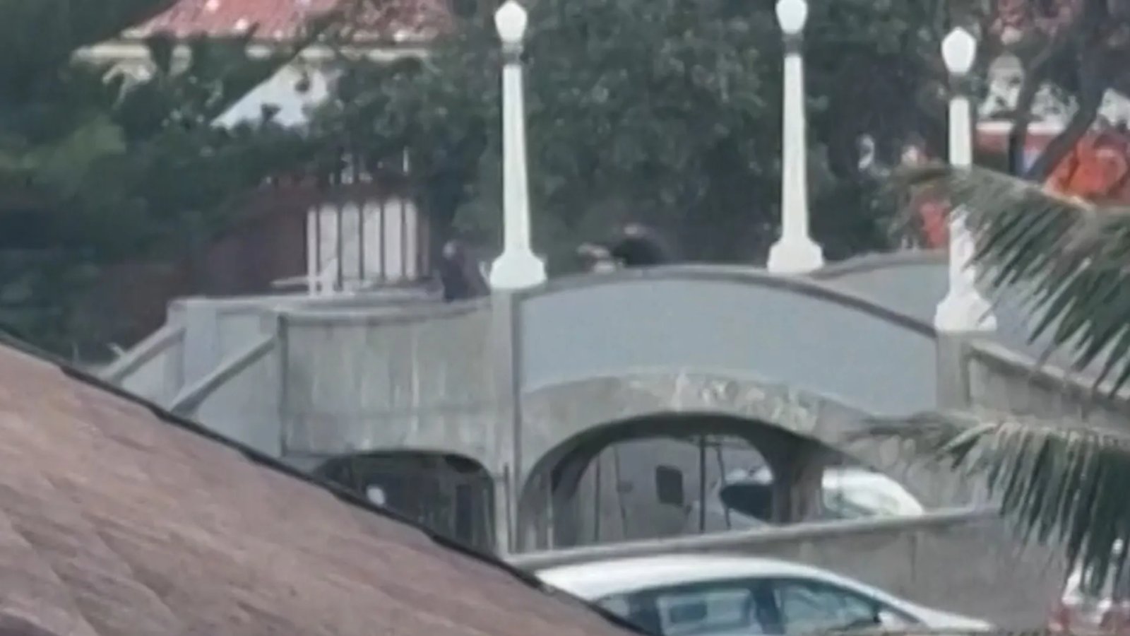 A close-up of a lit menorah during a Hanukkah celebration, with flickering candles and a festive background.