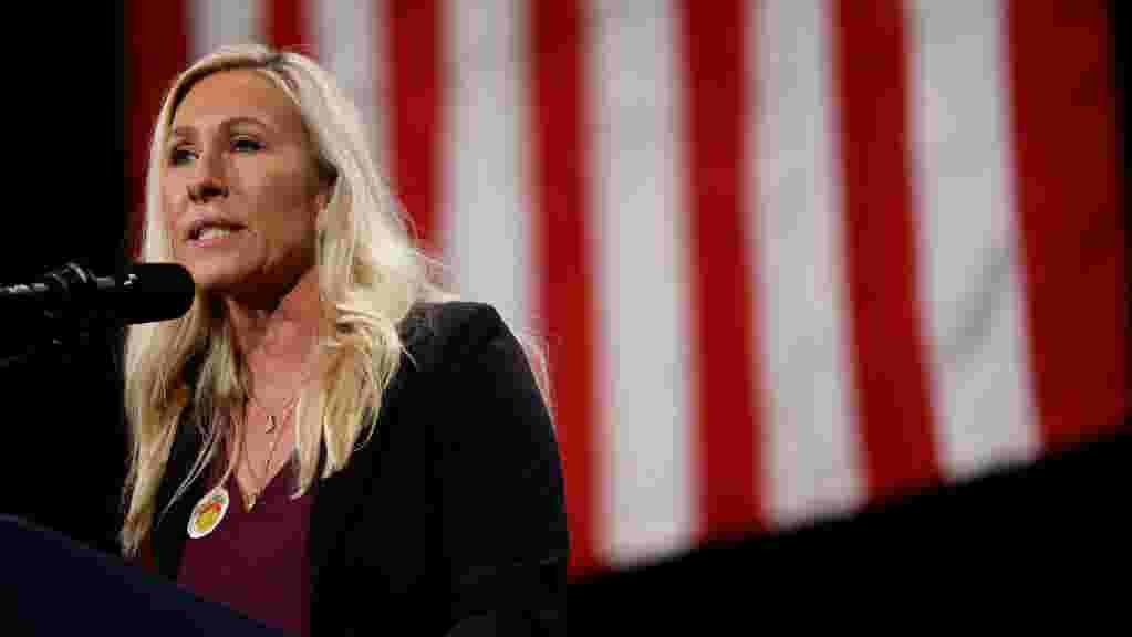 Donald Trump speaking at a rally, with a serious expression, gesturing with his hand.