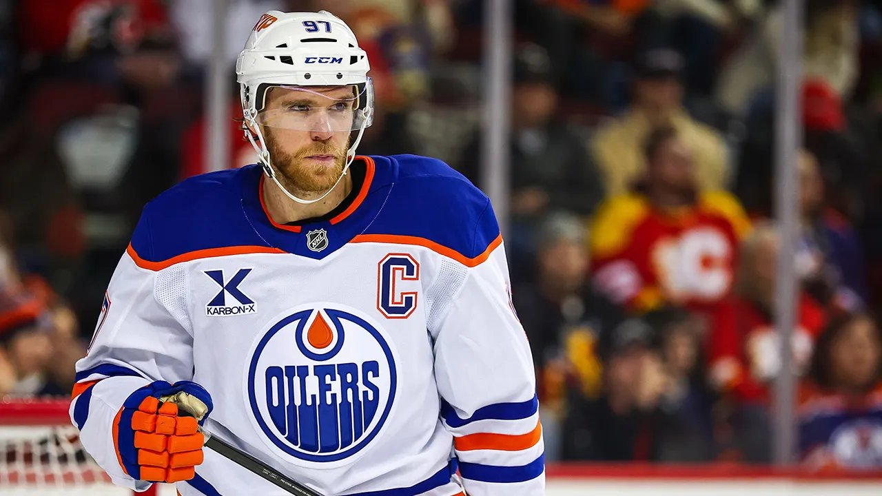 NHL star looking uneasy near a bottle of ketchup on a table.