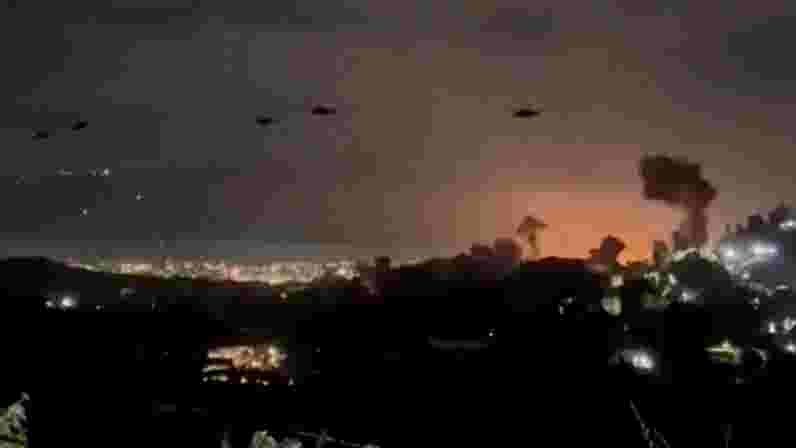 A somber Nicolas Maduro, likely after his capture, surrounded by figures in tactical gear.