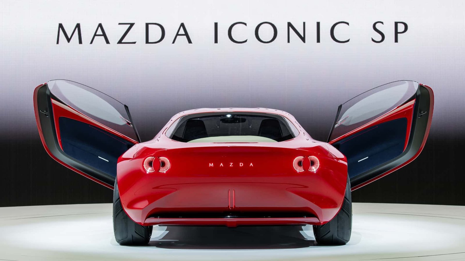 A sleek, modern sports car concept with design cues reminiscent of classic Mazda RX models, possibly a new rotary vehicle.