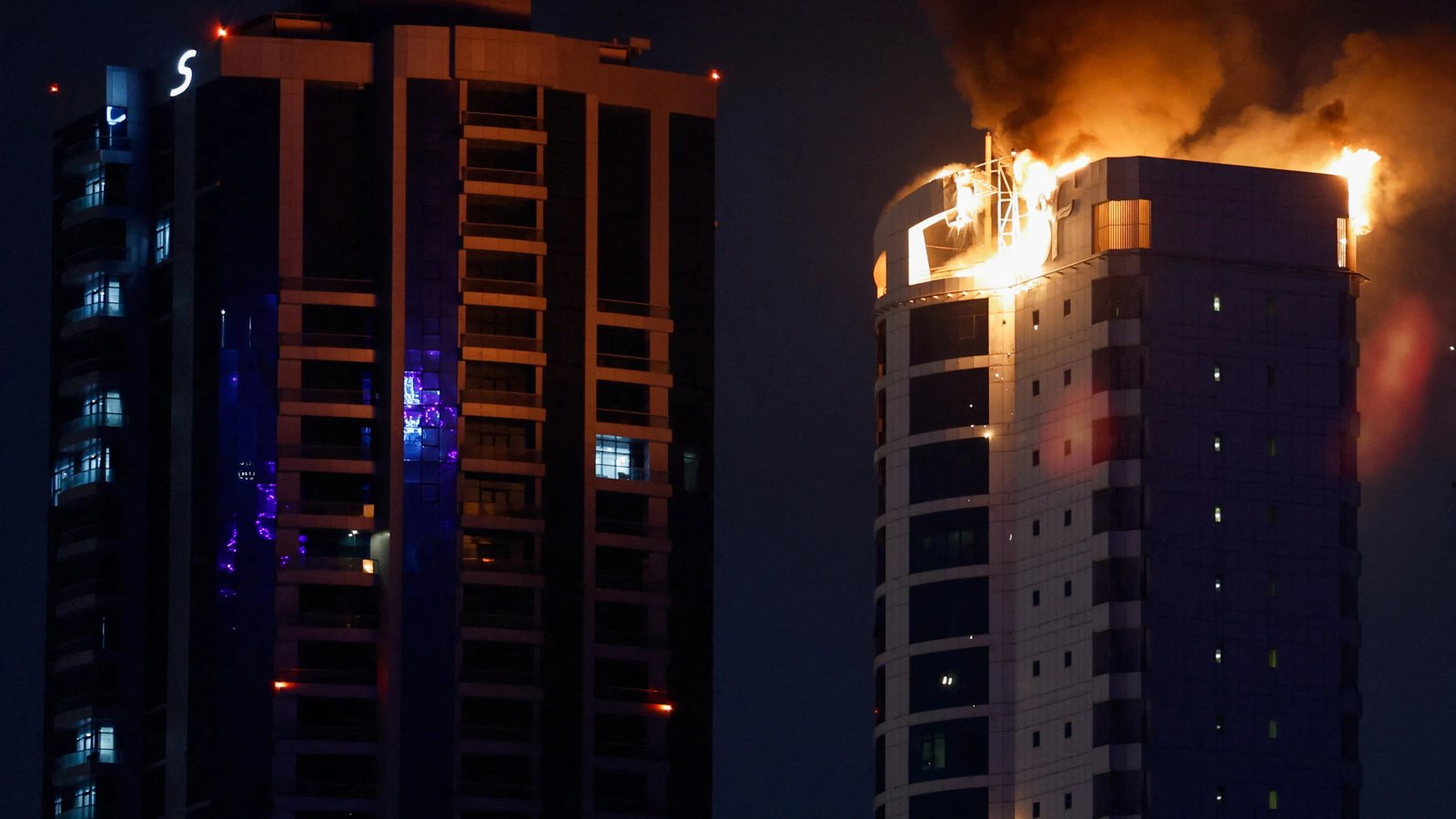 A sophisticated drone flying over a city skyline at dusk, representing the modern threat of drone attacks.