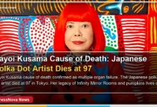 Yayoi Kusama wearing her signature red wig and polka dot outfit in her Tokyo studio