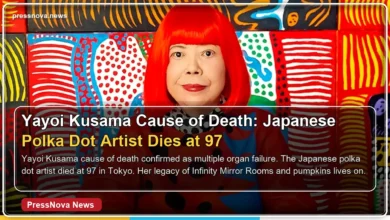 Yayoi Kusama wearing her signature red wig and polka dot outfit in her Tokyo studio
